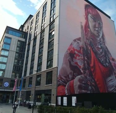 Keeper of Light mural of a nonbinary icon on the side of the Social Hub building
