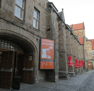 A view of the interior of the Pleasance Courtyard and its arched entrance.