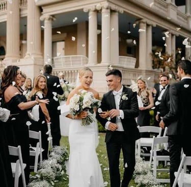 Bride and groom walking through a shower of rose petals