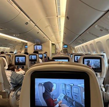 a group of people sitting in a saudi airline plane