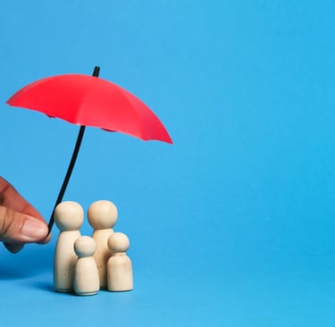 Hand holding a red umbrella over wooden peg dolls to represent family life insurance coverage.