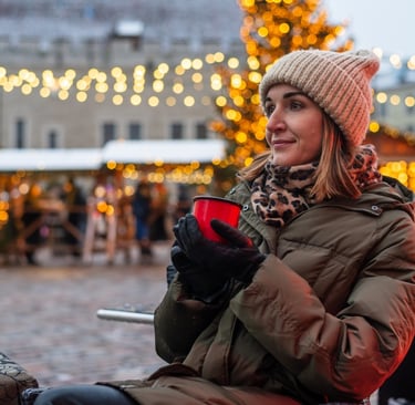 a woman in a hat and coat is holding a cup of coffee