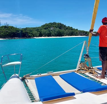 a man standing on a boat in the Nosy Be