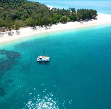 a boat in the water near a sandy beach nosy kalakajora Nosy Be