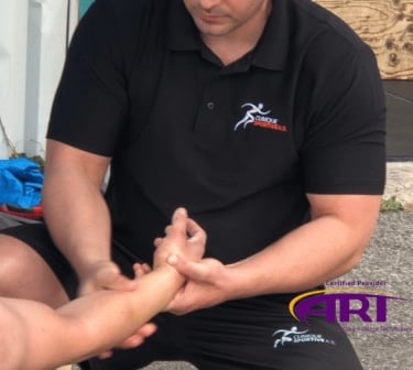 Thérapeute ART effectuant un traitement lors d'une compétition de Crossfit à Sainte-Julie. 