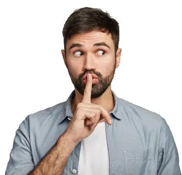 A man holding a finger over his mouth to signal to keep secrets