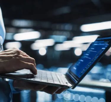 a man in a blue suit is holding a laptop
