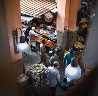 Busy market scene in Mauritius with vendors and customers at fruit and vegetable stalls under warm lighting