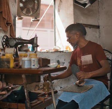 Cobbler and artisan at work in small workshop, Royal Road Mahebourg, Mauritius
