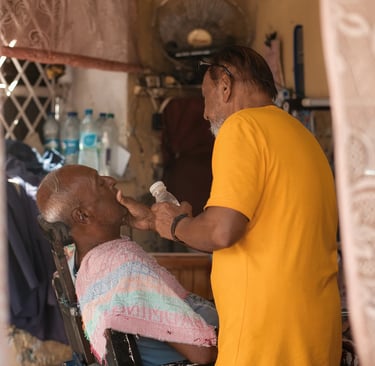 Traditional barber shop Royal Road Mahebourg, barber at work through ornate doorframe, Mauritius