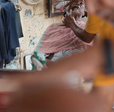 Barber giving a shave reflected in mirror, Royal Road Mahebourg, Mauritius