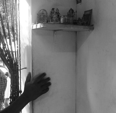 Mauritian home interior with hand on wall beside a small shrine, Cape Town Photography Festival 2025.