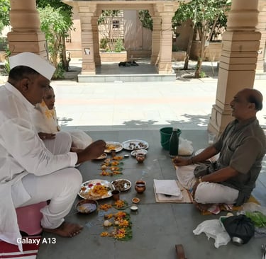 Elderly yajaman couple performing Matrugaya Shraddh Pooja with marigold offerings at Bindu Sarovar Siddhpur