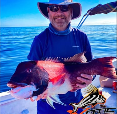 a man in a hat and sunglasses holding a fish