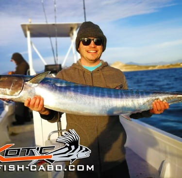 a man holding a fish on a boat