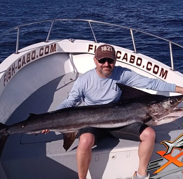 a man holding a large fish on a boat
