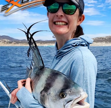 a woman holding a fish on a boat