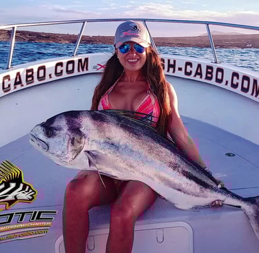 a woman in a bikini top and sunglasses holding a fish
