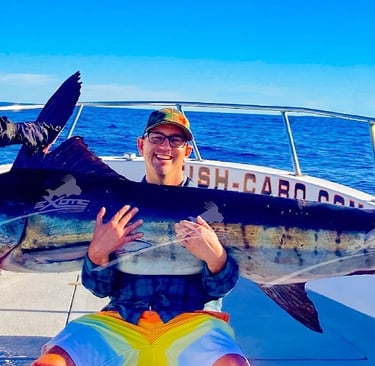 a man holding a fish on a boat