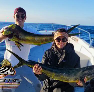 a man and woman holding two fish on a boat