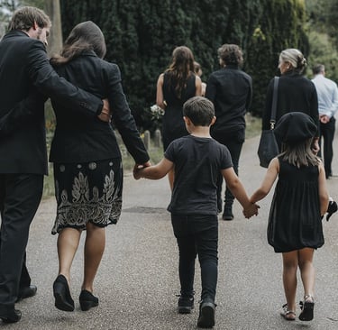 a group of people dressed in black clothing,  walking into a church. 