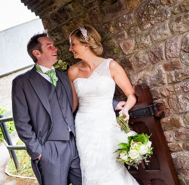 Photograph of a man and woman, looking happy on their wedding day. 