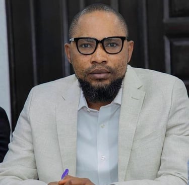a man in a suit and glasses sitting at a table