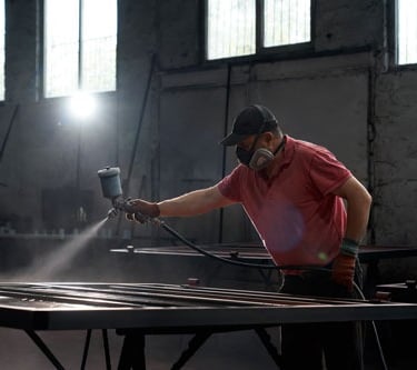 a man in a red shirt is spraying a metal table
