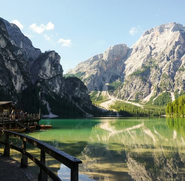 a mountain scene with a lake and a boat dolomites italy