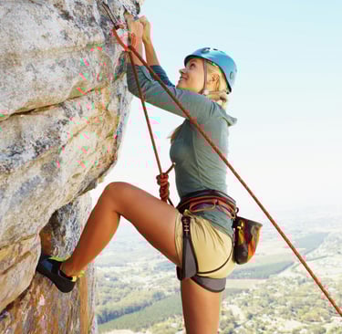 a woman climbing a rock 