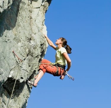 a woman climbing a rock face 
