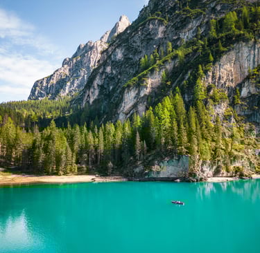 a boat in the water near a mountain dolomites italy