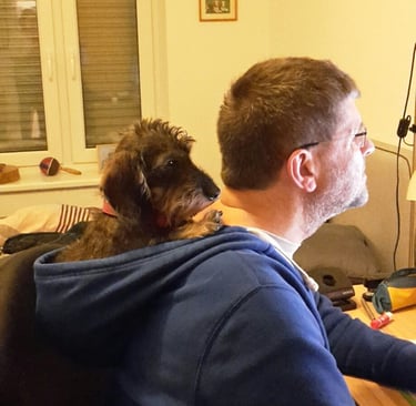 Martin und Zwergdackel Paul erledigen Büroarbeit.