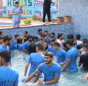 a man in a blue shirt is standing in a pool
