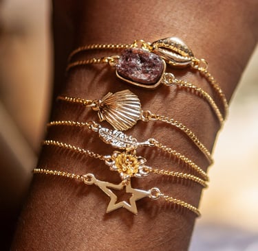o braço de uma mulher com pulseiras pratas e douradas. 