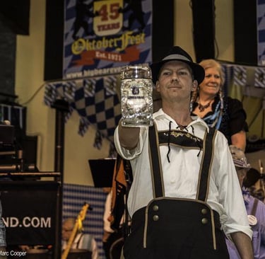 a man in a bavarian beer outfit holding a beer glass