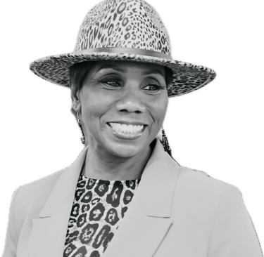 Smiling woman wearing a leopard print fedora hat and matching blouse with a stylish blazer.