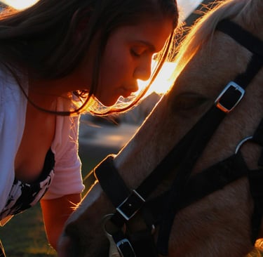 donna bacia in fronte un cavallo