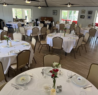 a table setting with white tablecloth and chairs