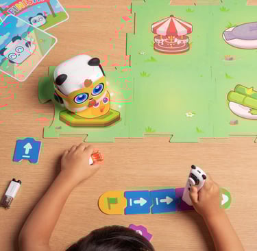 A young child plays with a colorful, screen-free robot on an interactive floor mat.