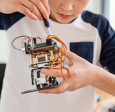 A student connects electronics and custom 3D-printed parts to an advanced robotics project.