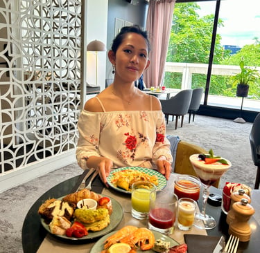 a woman sitting at a table with food and drinks