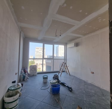 a room with a large window and a bucket of paint