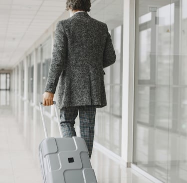 Executive pulling wheeled laptop bag through luxury hotel lobby