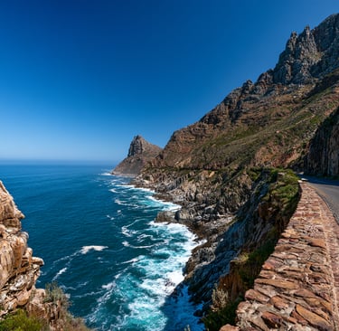 Scenic coastal road on Chapman's Peak Drive overlooking the blue ocean and rocky cliffs in Cape Town.