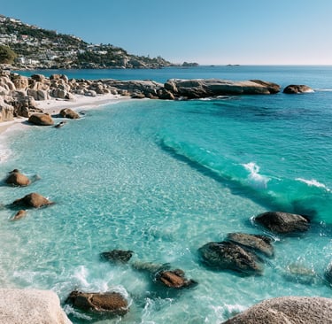 Aerial view of a secluded white sand beach with turquoise water and granite boulders in Cape Town.