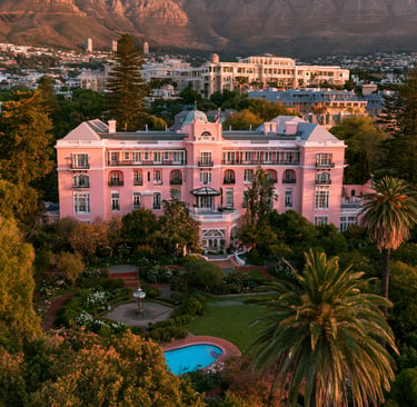 Aerial view of the pink Mount Nelson Hotel in Cape Town with Table Mountain in the background.