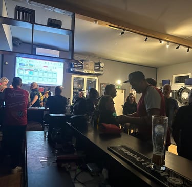 a man is standing in a bar with a glass of beer