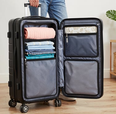 An open black hard-shell suitcase packed with organized folded clothes and mesh storage compartments.