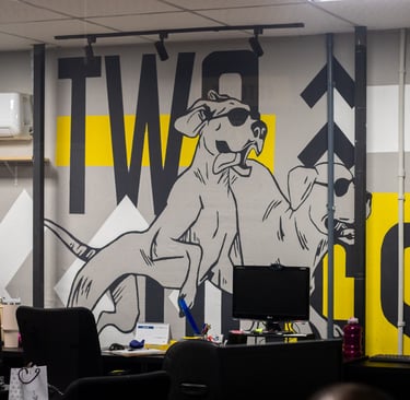 a dog sitting on a desk with a computer monitor